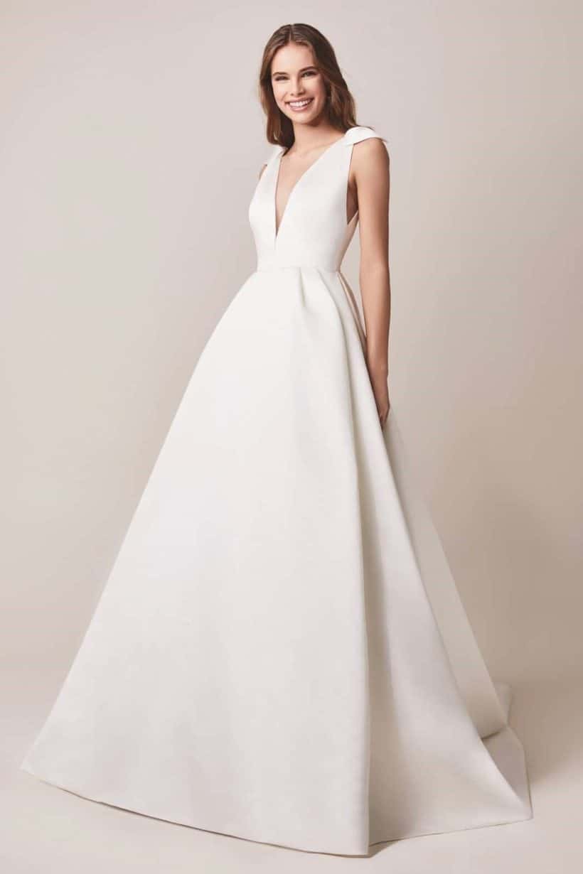 Elegáns szatén haute couture stílusban készült ujjatlan esküvői ruha mély V kivágással, a vállpántján masni díszítéssel valamint rejtett zsebekkel. Kollekció Jesus Peiro 2020, Style: 107 Image