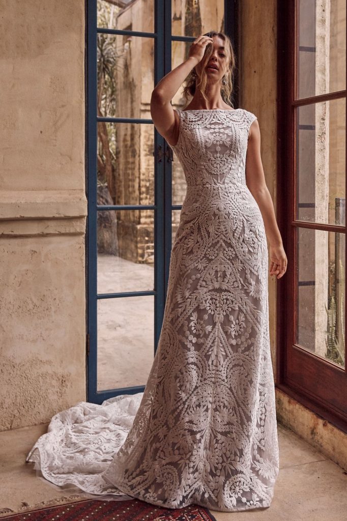 Csónakkivágású, ejtett vállú, bohém stílusú, A vonalú esküvői ruha mély hátkivágással az Evie Young menyasszonyi ruha kollekcióból. Style: Arrow Elölről fotózva