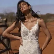 Vintage esküvőkre ajánljuk ezt a különleges matt csipkéből készült, elöl magasan sliccelt, sellő fazonú menyasszonyi ruhát az Evie Young 2021 évi "Outback" kollekcióból. A ruha bohó jellegét a különleges, lecsatolható ejtett váll biztosítja. Style: Rue.. Közelről fotózva