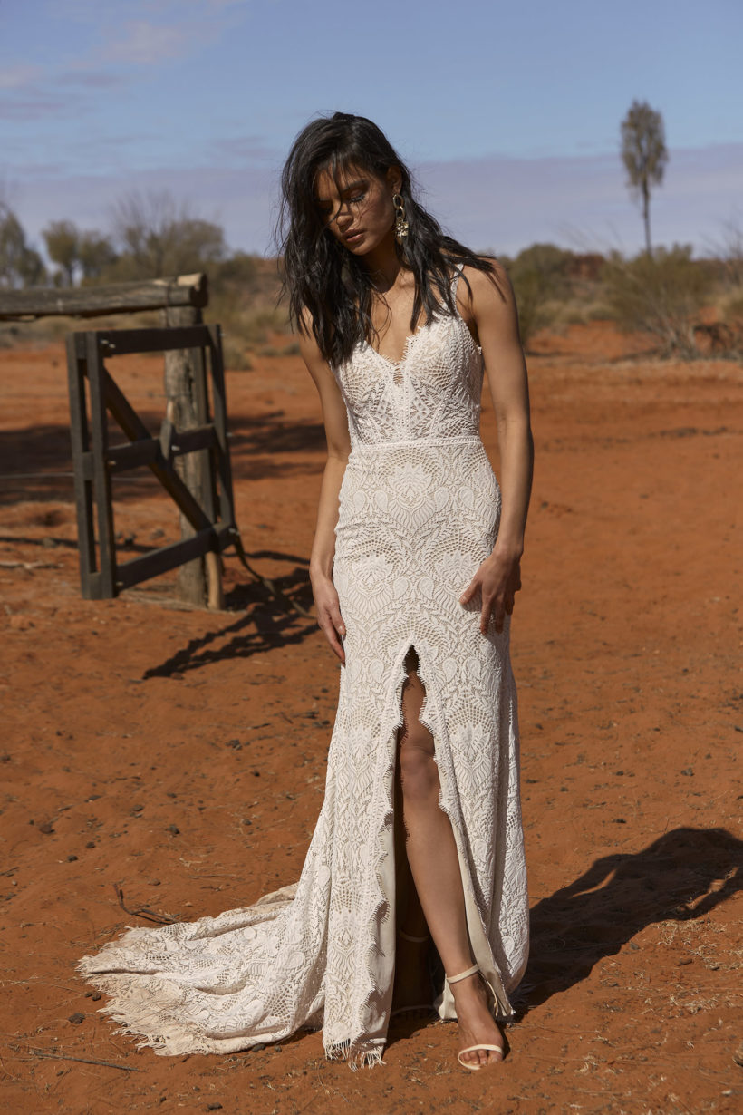 Vintage esküvőkre ajánljuk ezt a különleges matt csipkéből készült, elöl magasan sliccelt, sellő fazonú menyasszonyi ruhát az Evie Young 2021 évi "Outback" kollekcióból. A ruha bohó jellegét a különleges, lecsatolható ejtett váll biztosítja. Style: Rue. Image fotó