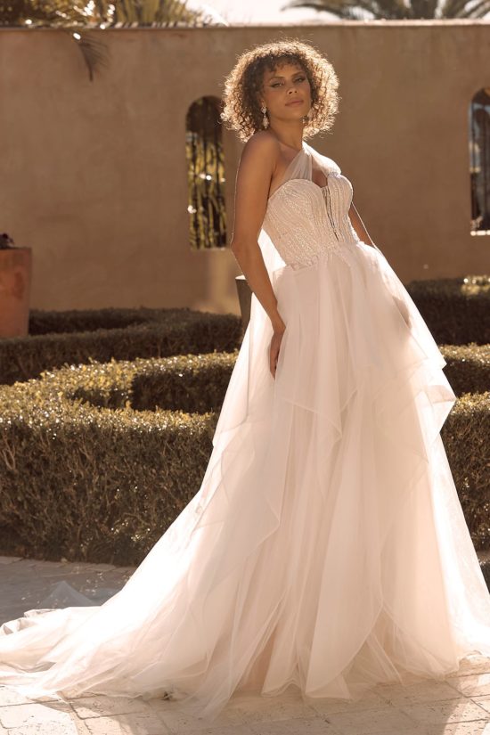 Romantikus, fodros tüll menyasszonyi ruha modern hercegnőknek, flitterekkel díszített csipkebodyval és félvállas tüll kiegészítővel a Madi Lane 2021 évi menyasszonyi ruha kollekcióból. Style: Bella. Image fotó