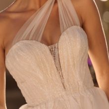 Romantikus, fodros tüll menyasszonyi ruha modern hercegnőknek, flitterekkel díszített csipkebodyval és félvállas tüll kiegészítővel a Madi Lane 2021 évi menyasszonyi ruha kollekcióból. Style: Bella. Közelről fotózva