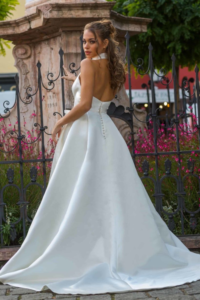 A vonalú, halter nyakú elegáns, letisztult, minimalista menyasszonyi ruha a 2022 évi Jesus Peiro kollekciónkból. Style: 150. Modell: Kecskés Enikő, Miss Universe Hungary szépségkirálynő, Fotó: Dévai Zoltán, Helyszín: Szentendre. Hátulról oldalról