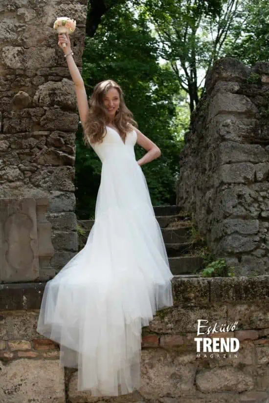 Dobos Evelin az Evie Young ''Lark' fehér menyasszonyi ruhában csokor virággal.