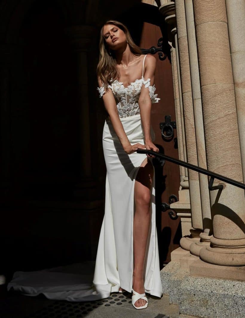 Modern, elegáns, egyszerű sellő menyasszonyi ruha csipke bodyval, magasan sliccelt szoknyával, spagettpánttal és ejtett karpánttal. Style: Evie Young "Lexi" elölről2