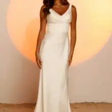 A vonalu, vállpántos V nyakkivágású lágy selyem menyasszonyi ruha mutatós uszállyal és széles övvel a derekán. Style: Jaxon a Madi Lane 2023 évi "Oasis" kollekcióból. Elölről