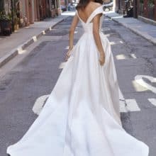 Minimál stílusú, egyszerű, magasan sliccelt szatén esküvői ruha ejtett vállal és széles övvel. A ruha érdekessége a rejtett zseb. Style: Morilee: Jonnie Hátulról