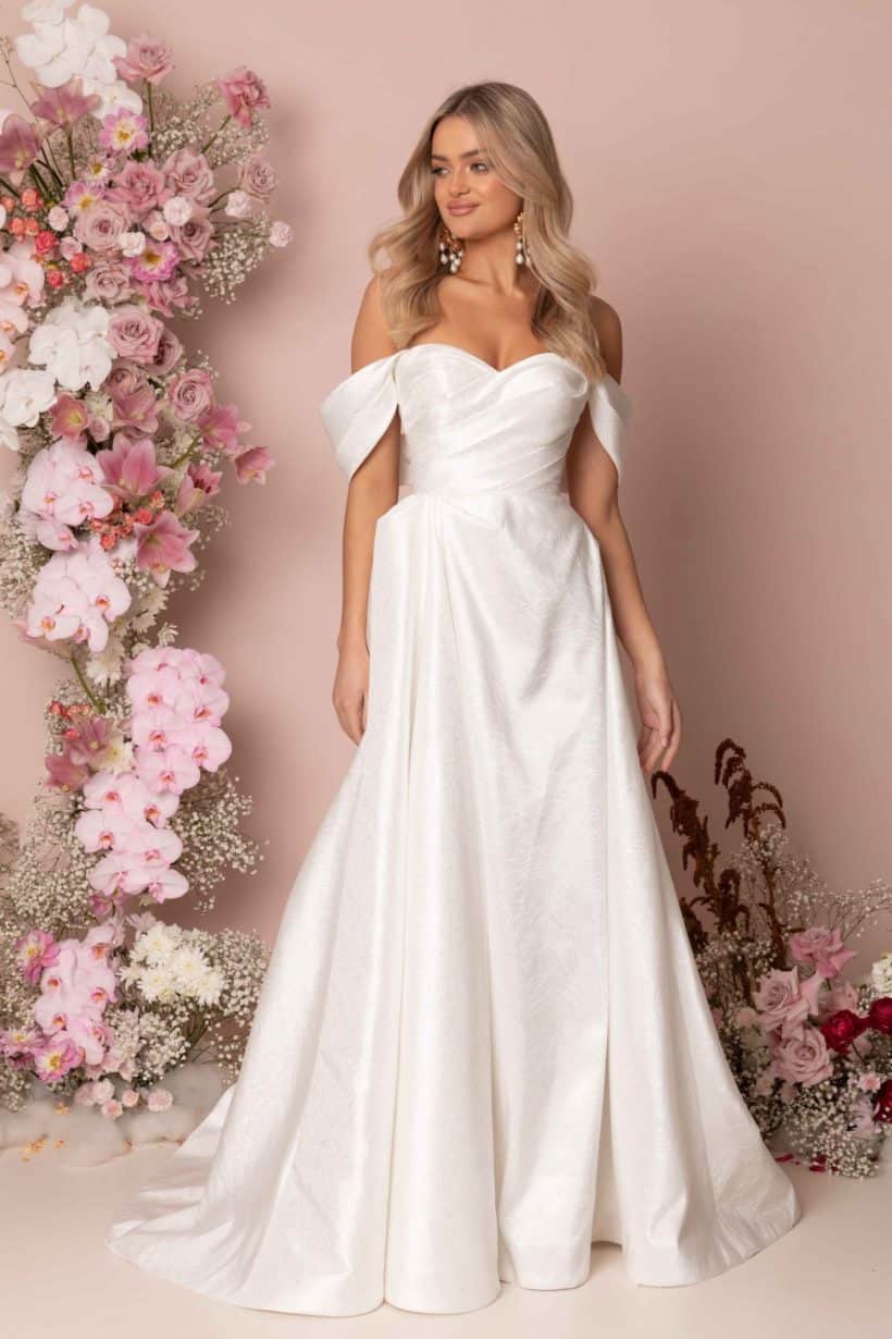 Zsebes menyasszonyi ruha lecsatolható karpánttal, melynek eleganciáját a nyomott mintás szatén anyag adja. Style: Madi Lane "Keaton"