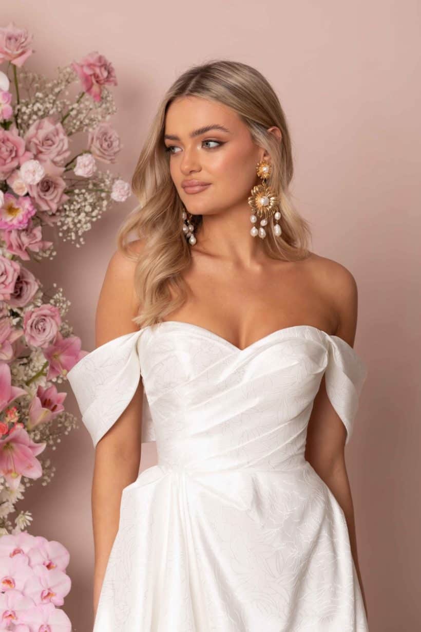 Zsebes menyasszonyi ruha lecsatolható karpánttal, melynek eleganciáját a nyomott mintás szatén anyag adja. Style: Madi Lane "Keaton" közelről
