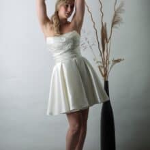 Olivía ruha váll nélküli szabással és fényes szatén szoknyával.