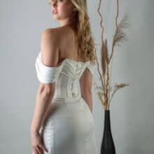 Teo ruha vállra ejtett pántokkal, testhez simuló szabással.